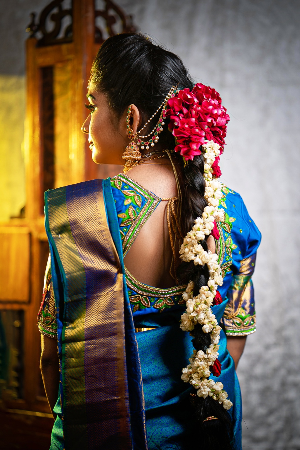 Back view of a bride in a blue saree with gajra decorated braid