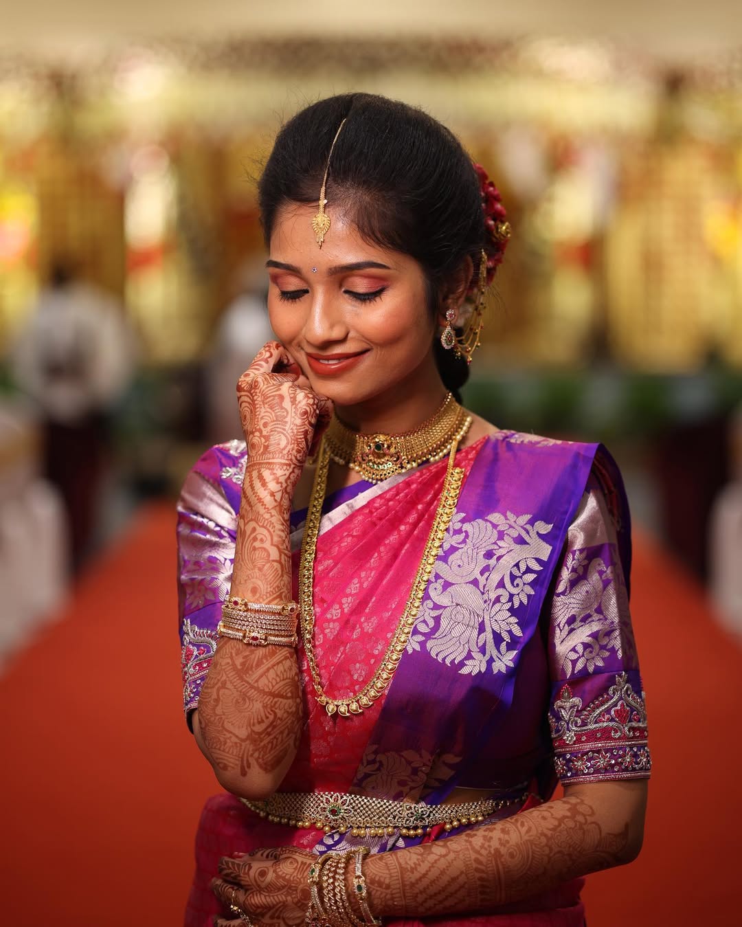 Bridesmaid posing gracefully in a pink and purple saree with henna-decorated hands